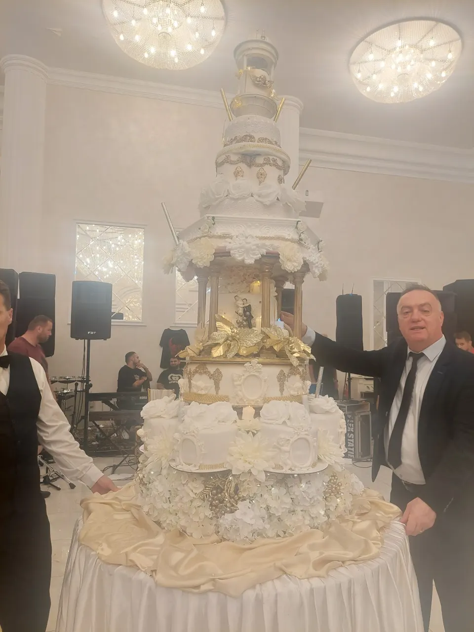 Tort de nuntă cu foișor, coloane aurii și trandafiri albi